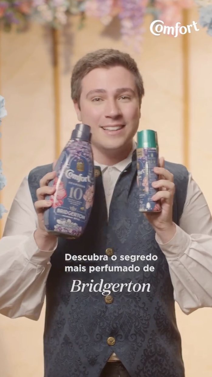 Ator em figurino de época segurando produtos Comfort da edição Bridgerton