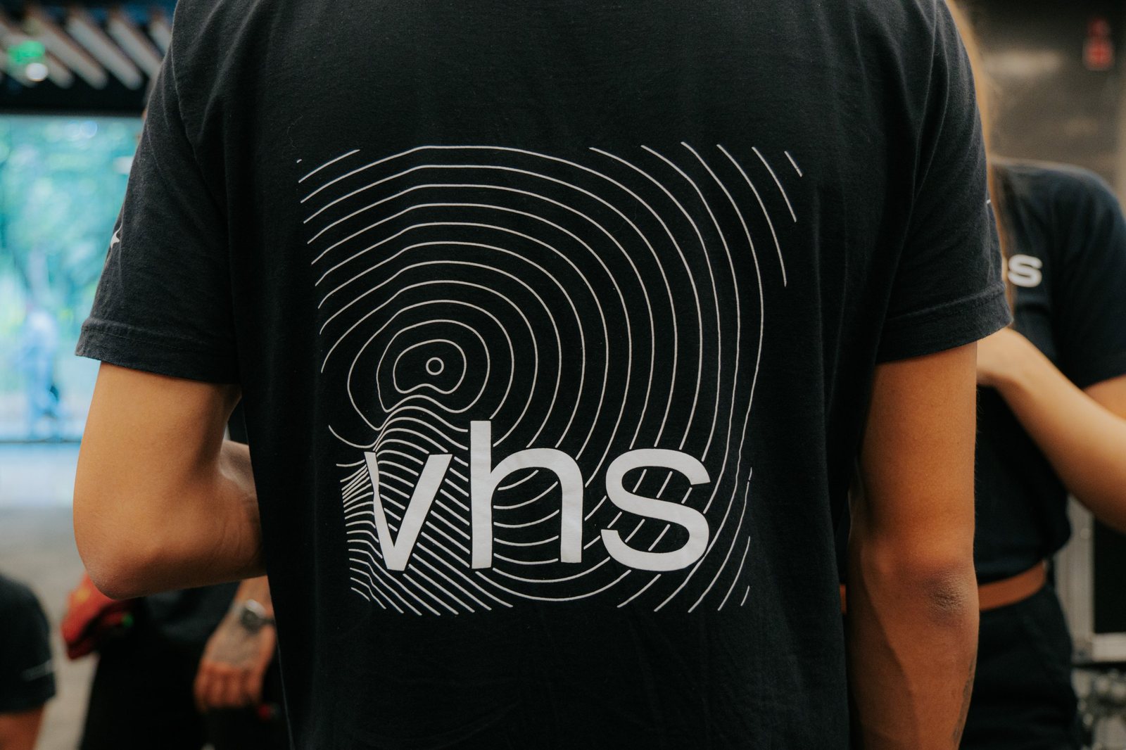 Camiseta da VHS com o logo e as ondas da identidade visual